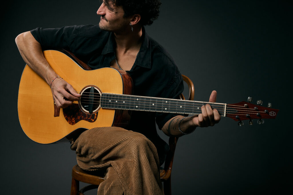 A person is playing a Thom Orgler Guitars Latemar Model in Bariton Version, PU High-gloss / Translucent Amber