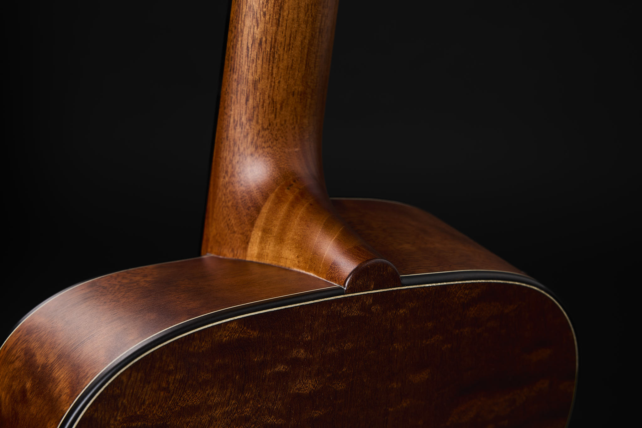 Close-up rear angled view of Thom Orgler Guitars’ Comfortwave—3D-bent side at the neck heel—for ergonomic play and easier upper-fret access.