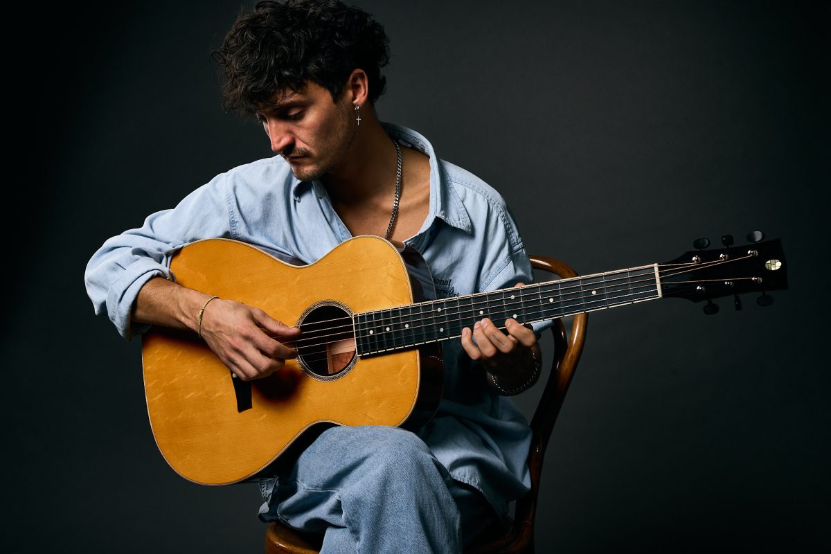Guitarist playing a Thom Orgler Vajolet (Orchestra Model) acoustic in a studio—close-up of hands, spruce top, fretboard, and headstock.